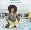 A woman is washing dishes in a kitchen sink, with pots and pans visible on the counter. Náhled obrázku produktu
