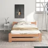 A bedroom scene with a wooden bed frame, bedding, a nightstand with decorative items, and a piece of abstract art on the wall. Náhled obrázku produktu