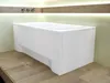 A white bathtub with a skirt is shown in a bathroom setting with wooden flooring and subtle lighting. Produktbild-Vorschau