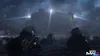 Several soldiers in tactical gear wading through rough, dark water at night, with a large, imposing structure in the background illuminated by searchlights. Produktbild-Vorschau