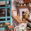 A miniature coffee shop scene with various coffee-related items on display. Anteprima dell’immagine prodotto