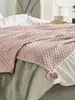 A pink textured blanket is draped over a bed with white and gray bedding. Náhled obrázku produktu