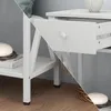 A collage showing details of a white nightstand, including its legs, shelf, and an open drawer. Voir les images du produit