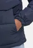 A close-up shot of a person's hand in the pocket of a navy blue puffer jacket. Produktbild-Vorschau