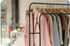 A clothing rack with several garments hanging on it, displayed in what appears to be a retail or boutique setting. Podgląd zdjęcia produktu