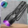 A black tactical LED flashlight with a purple light emitting from the lens, placed on a wooden surface against a textured gray background. A circular graphic with a flashlight icon is in the upper left corner. Produktbild-Vorschau