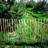 A rustic wooden fence in a garden setting with lush green grass and trees in the background. Produktbild-Vorschau
