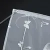 A close-up view of a white sheer curtain with a butterfly pattern. Produktbild-Vorschau