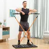 A man is performing an exercise using a portable full-body training system in a room. Podgląd zdjęcia produktu