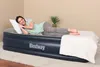 A woman is lying on an inflatable mattress in a room. Náhled obrázku produktu