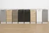 A row of kitchen base cabinets with different finishes displayed against a white wall and on a wooden floor. Produktbild-Vorschau