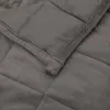 A close-up view of a gray weighted blanket, showing its quilted texture and soft fabric. Náhľad obrázku produktu
