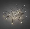 A string of LED lights is arranged in a tangled pile on a gray surface. Produktbild-Vorschau