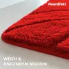 A close-up of a red bath mat with a textured surface. Produktbild-Vorschau