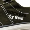 A close-up view of a green shoe with white stitching and branding. Voir les images du produit