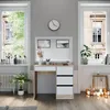 A vanity table with drawers and a mirror, set in a well-lit room with windows. Náhled obrázku produktu