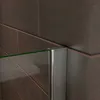 A close-up view of a shower wall or bathtub screen corner, showing the glass panel and its metallic frame against a tiled wall. Produktbild-Vorschau