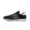 A side view of a black New Balance sneaker with a white 'N' logo on a white background. Voir les images du produit