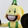 Close-up of a yellow plush toy character with a green striped party hat. Produktbild-Vorschau