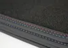 A close-up view of the edge of a car floor mat, showing the black carpet and stitched trim in red and blue. Voir les images du produit