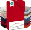 A stack of folded fitted sheets in various colors, with a prominent red sheet in the foreground. A label with the OEKO-TEX logo is visible on the red sheet. Produktbild-Vorschau