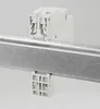 A white electrical component is mounted on a metal rail. Produktbild-Vorschau