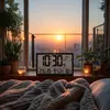 A digital weather station displaying time and temperature sits on a windowsill in front of a sunset view. Produktbild-Vorschau
