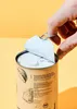 A hand is opening a can of coconut milk. Produktbild-Vorschau