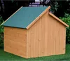 A wooden dog house with a green roof sits on artificial grass, with trees and foliage in the background. Voir les images du produit