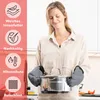 A woman in a kitchen is holding a pot with oven mitts on. Anteprima dell’immagine prodotto