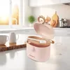A pink portable milk powder container is shown open on a kitchen counter. Produktbild-Vorschau