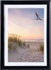 A framed photograph of a beach scene at sunset with a seagull flying. Produktbild-Vorschau