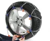 A car tire with snow chains being fitted. Produktbild-Vorschau