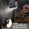 A hand holding a cordless drill with its LED light illuminating a tree trunk. The background shows construction equipment. Náhled obrázku produktu