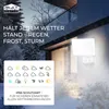 A white LED outdoor light fixture is mounted on the side of a house, with a snowy, wintery scene in the background. A graphic overlay displays weather icons and text. Produktbild-Vorschau