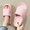 Rosa Slide-Sandale an einem Fuß mit rot lackierten Zehennägeln, weitere rosa Slide-Sandale in einer Hand gehalten Náhľad obrázku produktu