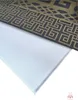 A close-up view of a decorative panel with a geometric pattern and a white surface. Produktbild-Vorschau