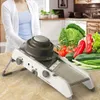 A person is preparing vegetables in a kitchen using a mandoline slicer. Produktbild-Vorschau