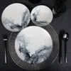 A table setting with plates, cutlery, and glasses on a dark tablecloth. Anteprima dell’immagine prodotto