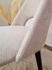 A close-up view of the textured fabric of a chair, with a hint of dried reeds in the background. Produktbild-Vorschau
