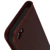 A close-up view of a brown leather flip case for a smartphone, showing the stitching and a cut-out for a camera or button. Voir les images du produit