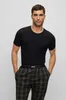 A man wearing a black t-shirt and plaid pajama pants. Produktbild-Vorschau