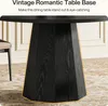 A close-up of a black round dining table base with gold trim, set in a room with a chair and a patterned rug. Produktbild-Vorschau