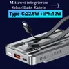 Close-up of a silver power bank with integrated charging cables and ports, with text overlays highlighting its features. Produktbild-Vorschau