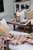 A cozy outdoor seating area with a small fire pit on a wooden table, set up for making s'mores. Produktbild-Vorschau