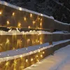 A wooden fence covered in snow and decorated with warm white LED lights. Produktbild-Vorschau