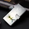A close-up shot of a flip phone case with a lotus flower design, resting on a dark surface. Produktbild-Vorschau