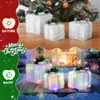 A split image showing Christmas gift boxes, one set unlit in daytime and the other lit up at night. Anteprima dell’immagine prodotto