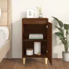 A brown wooden nightstand with an open door, placed next to a bed. The nightstand has two shelves, with books on the top shelf and decorative items on the bottom shelf. A potted plant is visible to the right of the nightstand. Náhled obrázku produktu