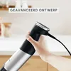 A hand holding a black and silver immersion blender in a kitchen setting. Produktbild-Vorschau